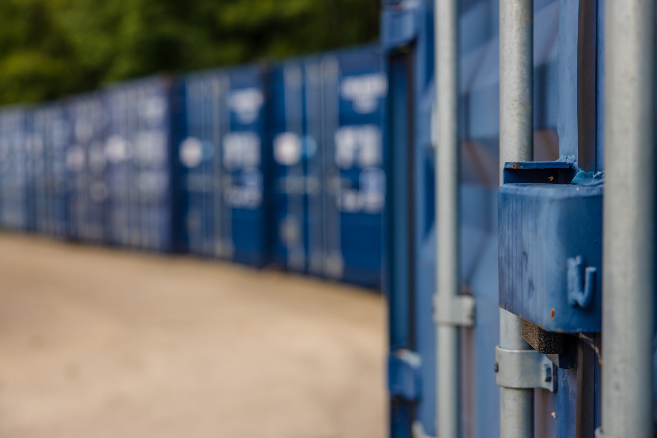 Close-up of blue storage container with locking mechanism, artistic shot with blurred containers in the background.