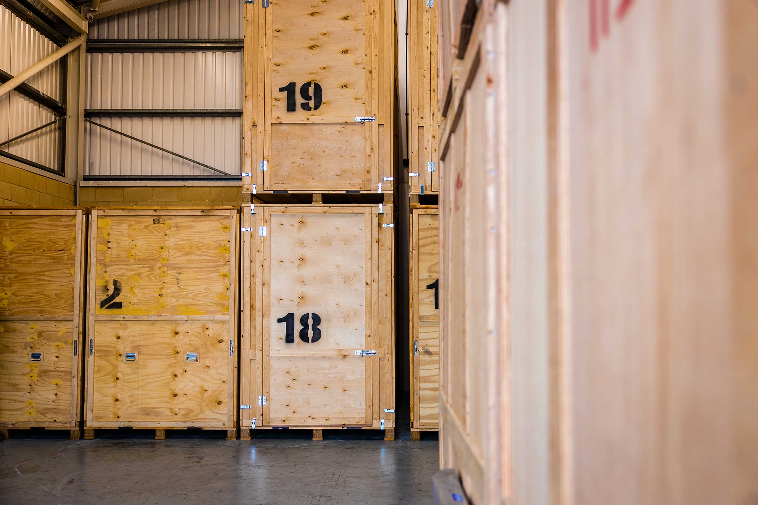Rows of storage boxes in a spacious warehouse with numbering system on the front.