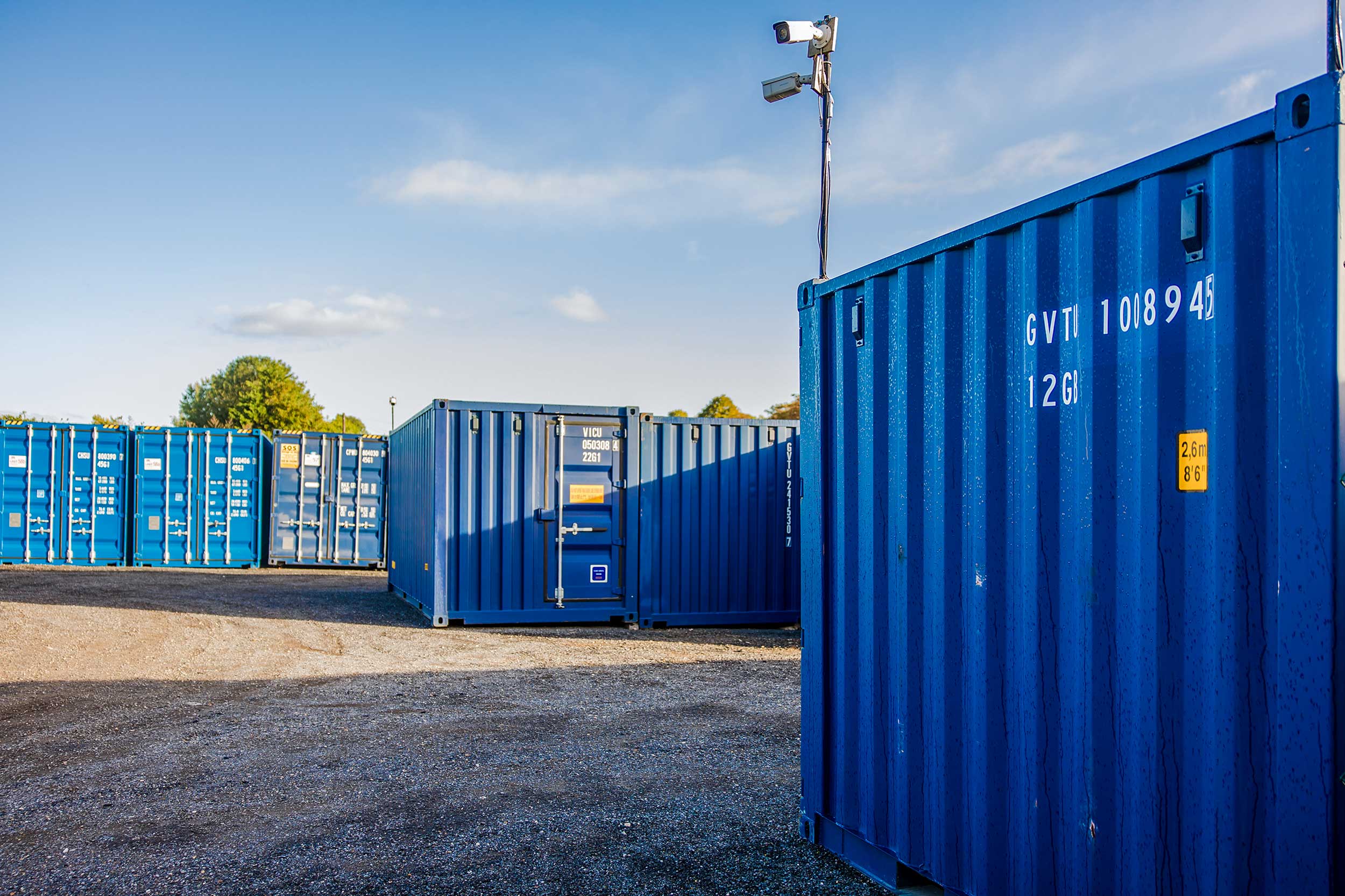 A large open area filled with numerous blue storage containers and cctv equipment.